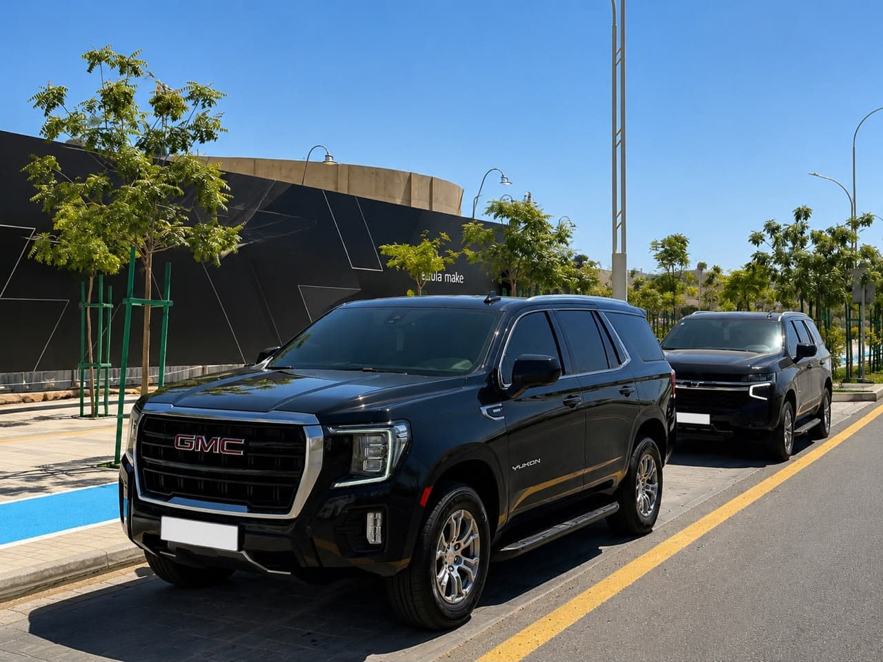 Two black GMC Yukons from the fleet