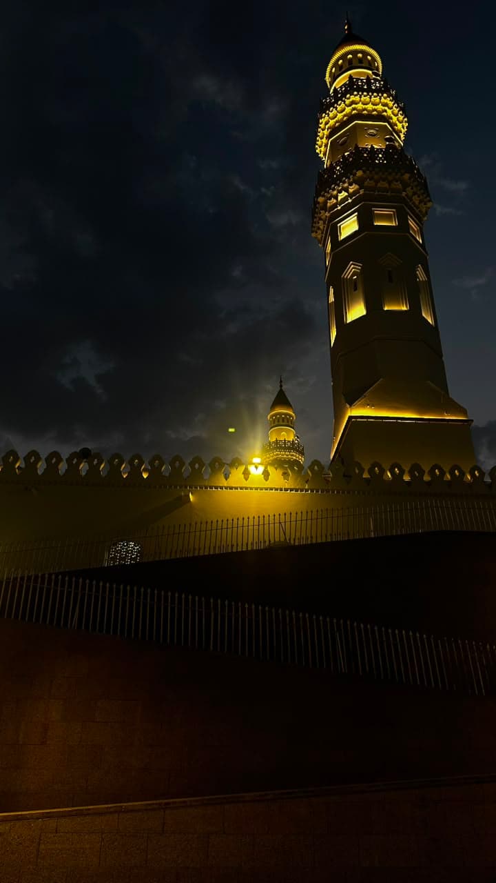 A minaret lit against the night sky
