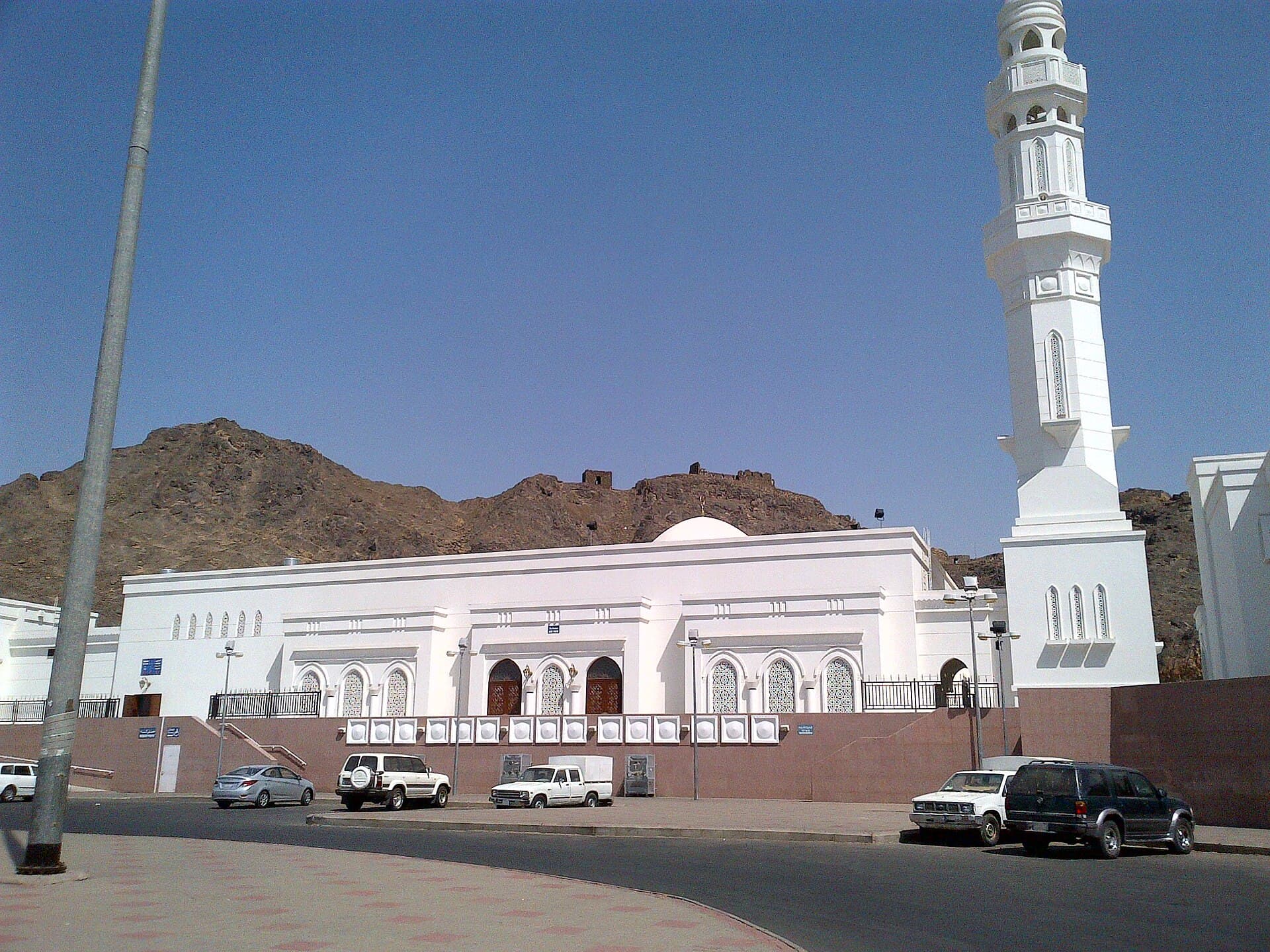 A mosque at the Seven Mosques site in Medina, below the rocky ridge behind it